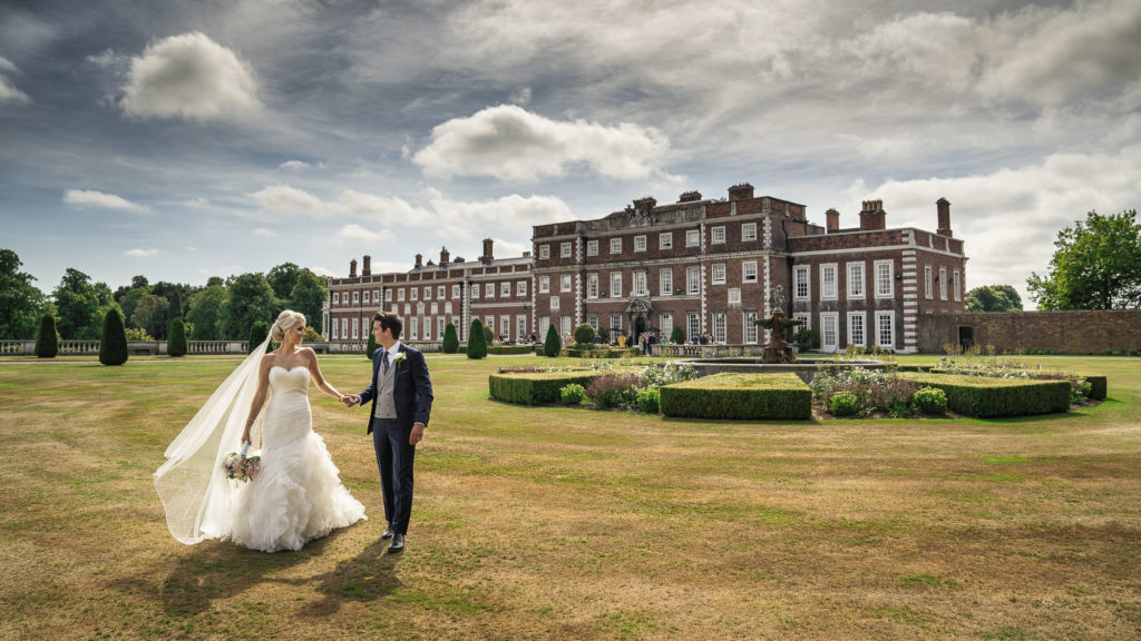 Bride and Groom walking in the grounds knowsley Hall on a beautiful sunny summer's day