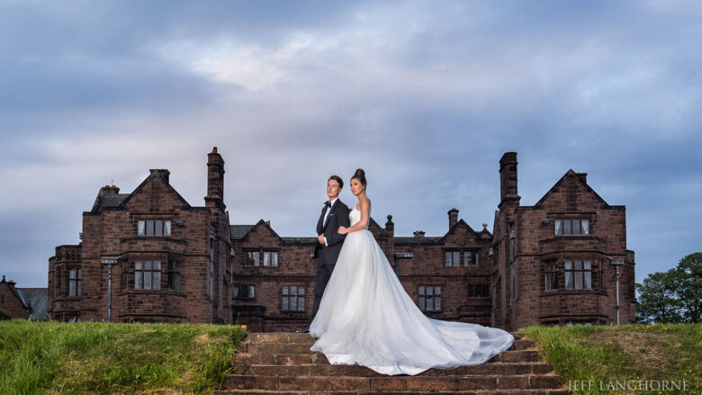 Bride & Groom elegantly posing together in the evening with Thornton Manor in the background