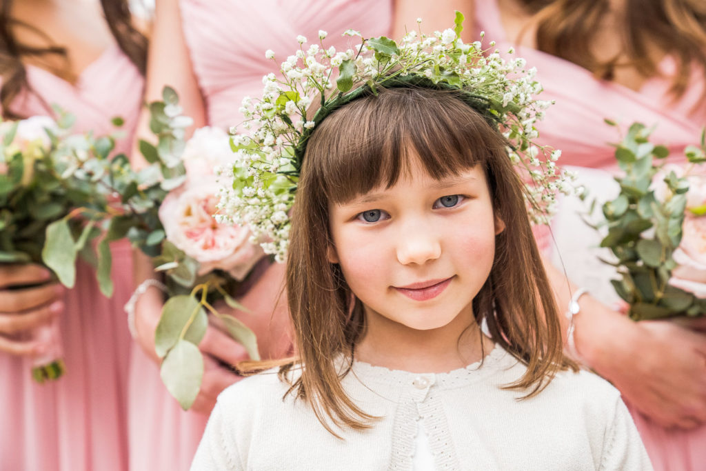 Flower girl with full gypsophila headdress with bridesmaids behind her