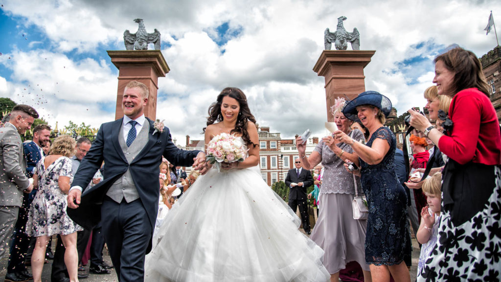 Bride and Groom laughing having just finished a confetti run at Knowsley Hall