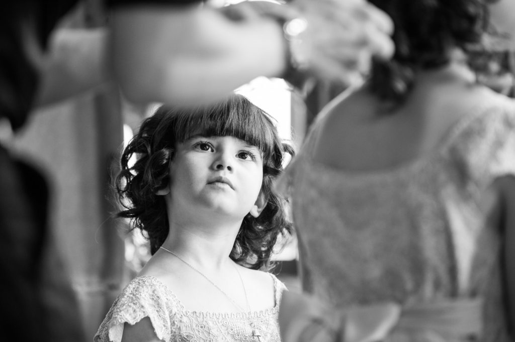 Flower girl watching on in fascination as another Flower girl has her hair done
