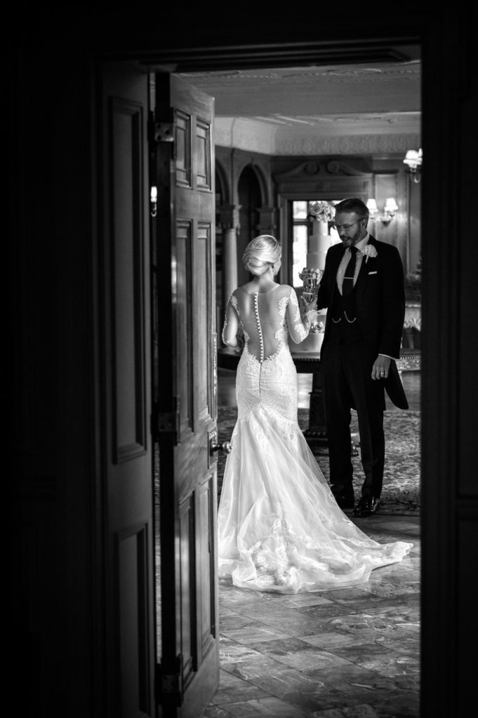 Newlyweds finding a quiet moment in a corridor drinking champagne