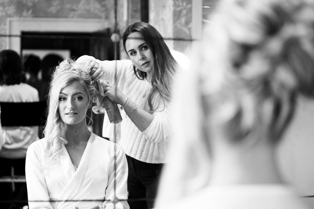 Bride having her curls teased by her hairdresser during her morning preparations