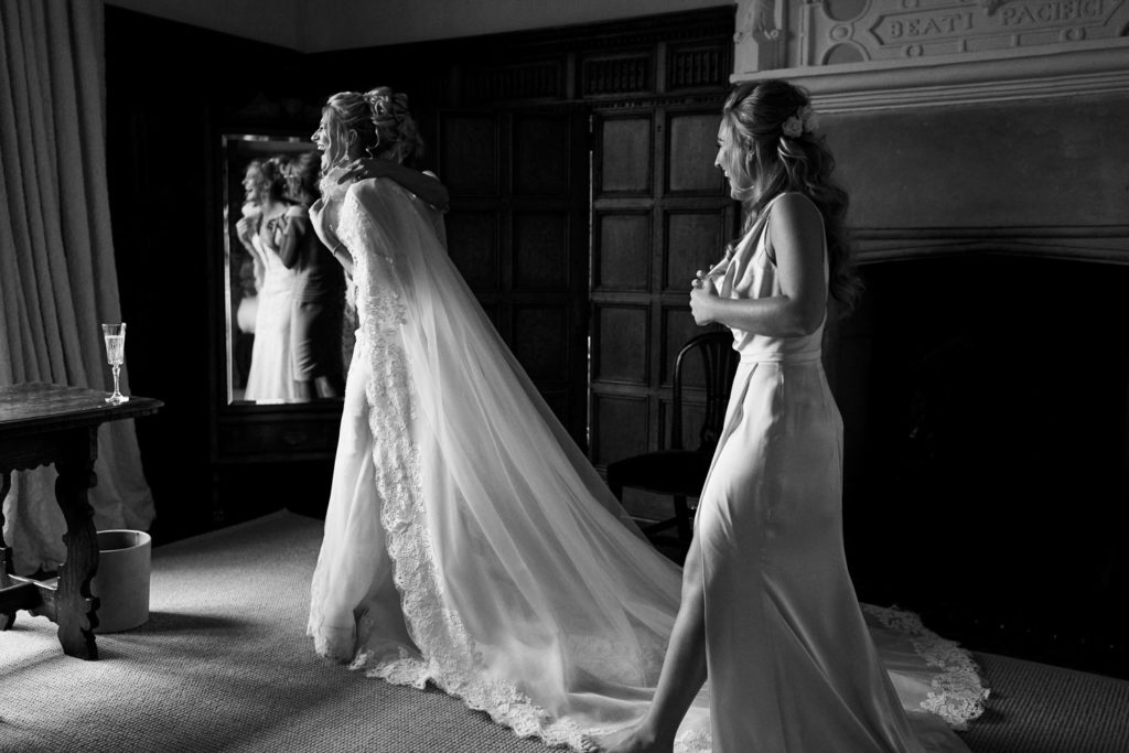 Bride with her mother and a bridesmaid as they work out how to place her Cathedral veil