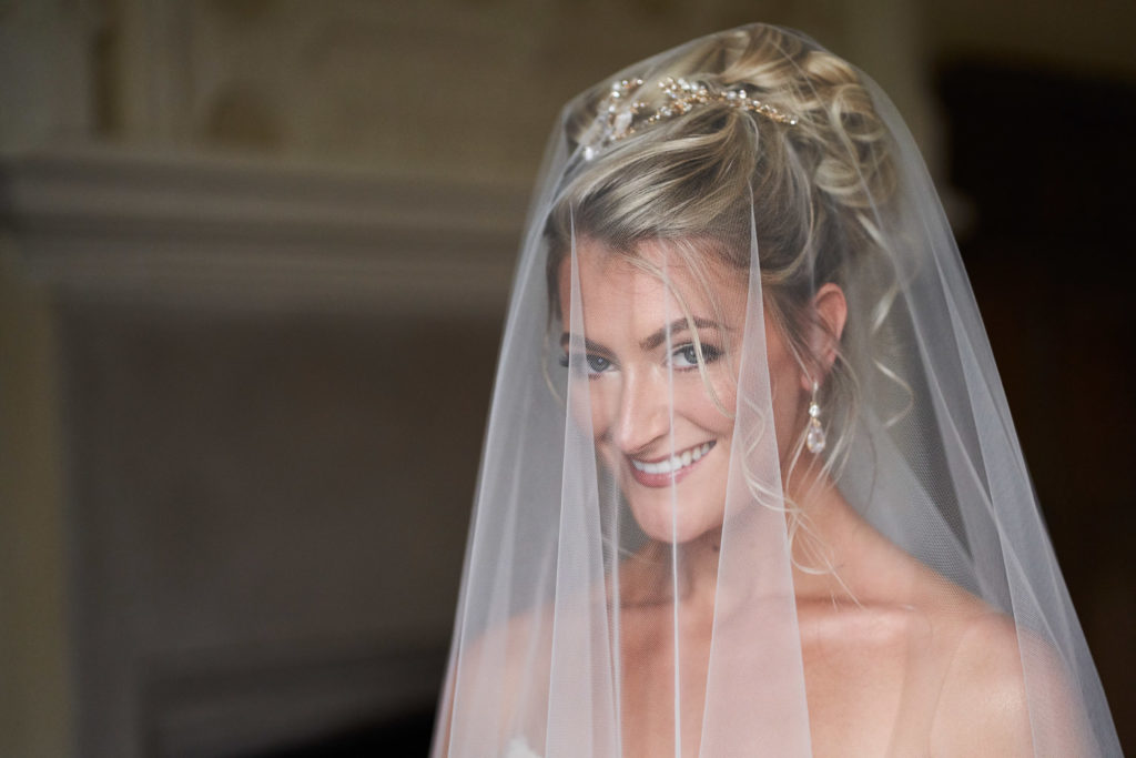 Beautiful head shot of bride looking into camera from under her veil