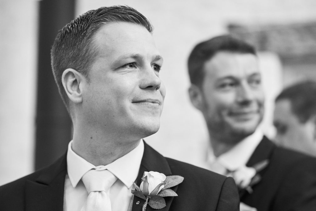 Groom glancing back over his shoulder to see his bride with a look of emotional joy