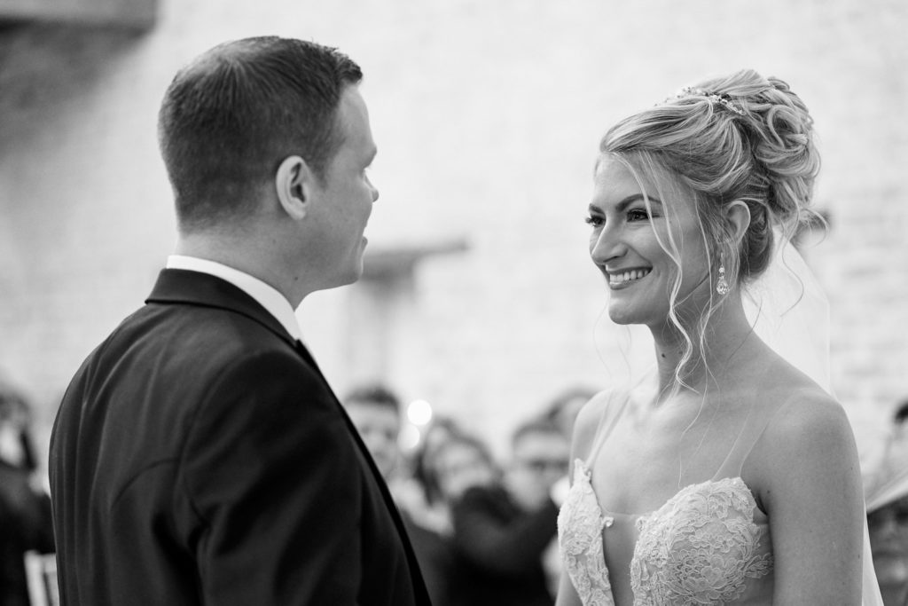 Bride and groom stood smiling at each other having just exchanged vows