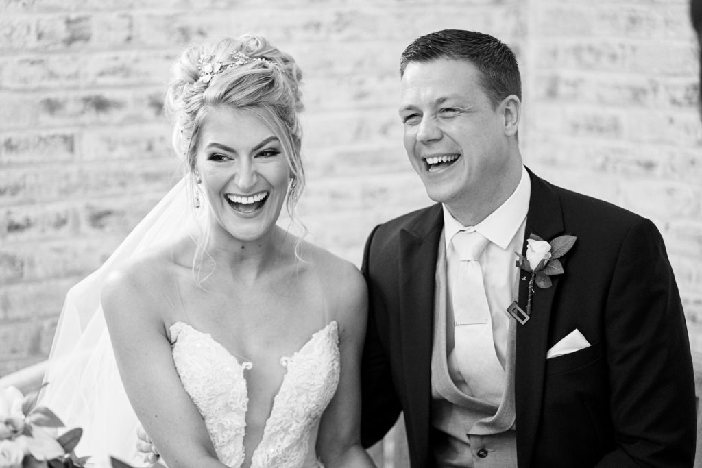 A very happy bride and groom waiting to sign the official register