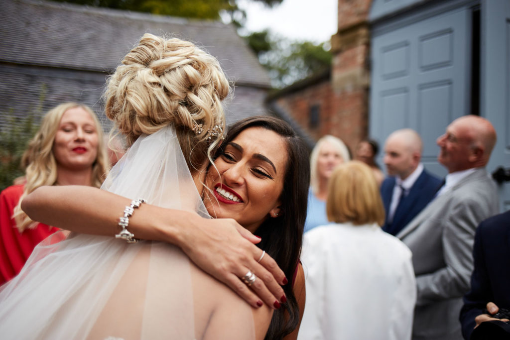 Bride being hugged by congratulating guest
