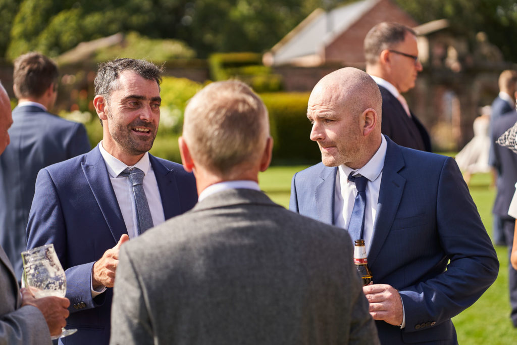 Guests mingling on the lawns enjoying drinks and chatting