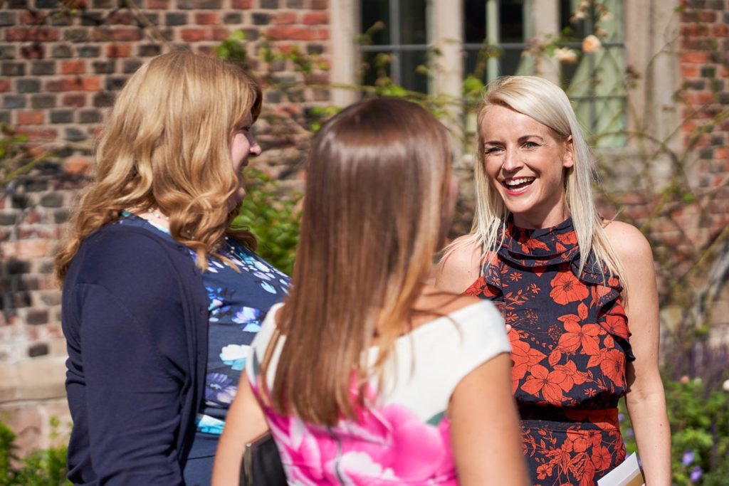 A trio of ladies chatting and laughing during the wedding drinks reception