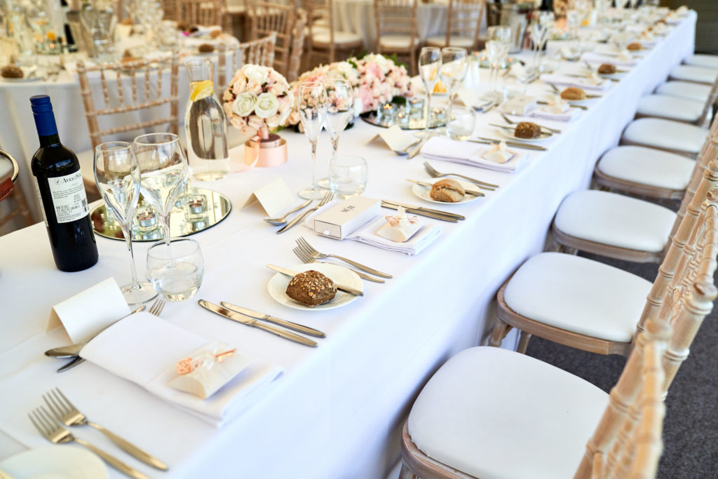 Top table place settings featuring wedding favours and bridesmaids bouquets