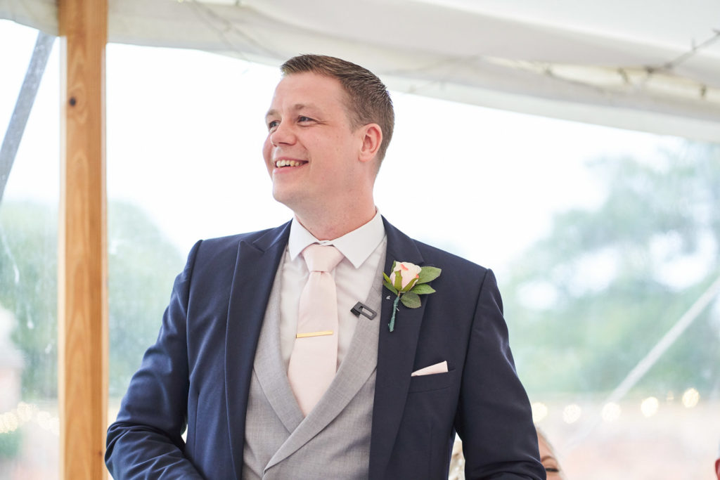 Groom smiling as he begins his wedding breakfast speech