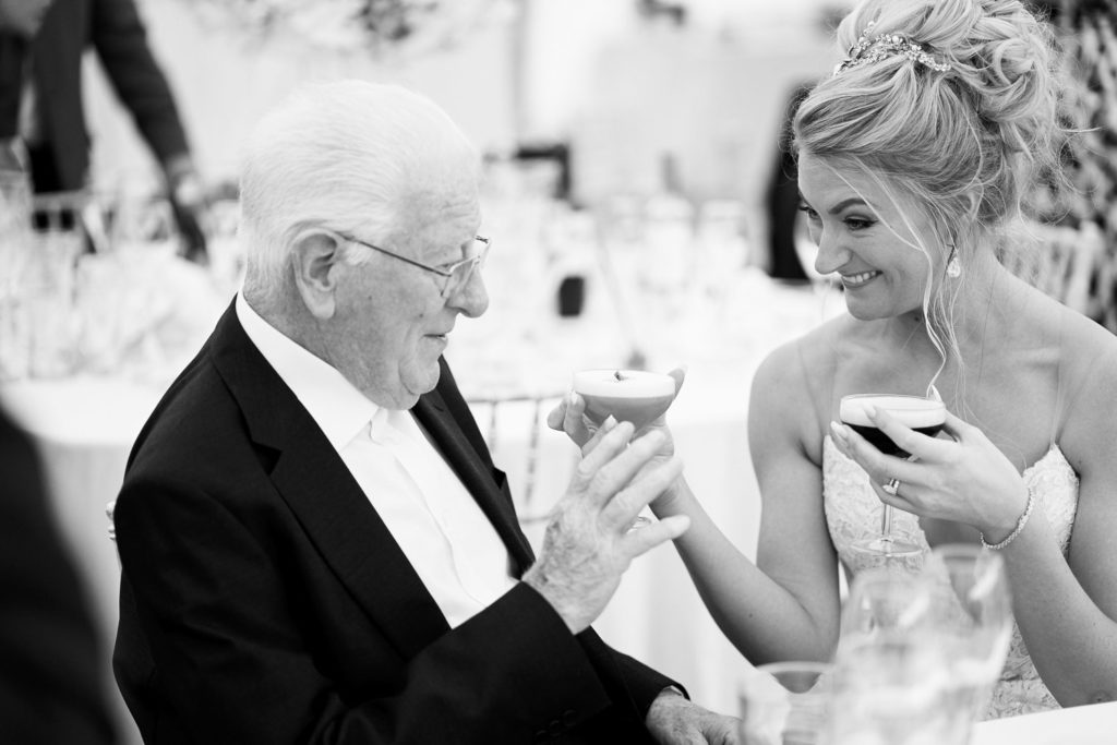 Bride shares a fancy cocktail with her Grandfather who doesn't look too keen