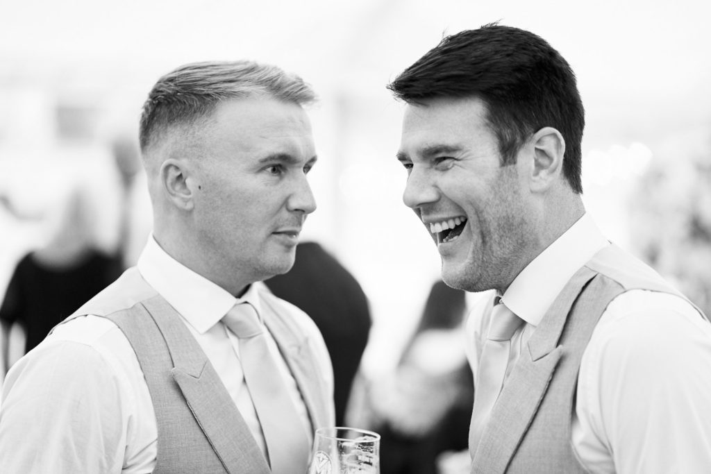 Ushers laughing as they mingle waiting for the evening party to start