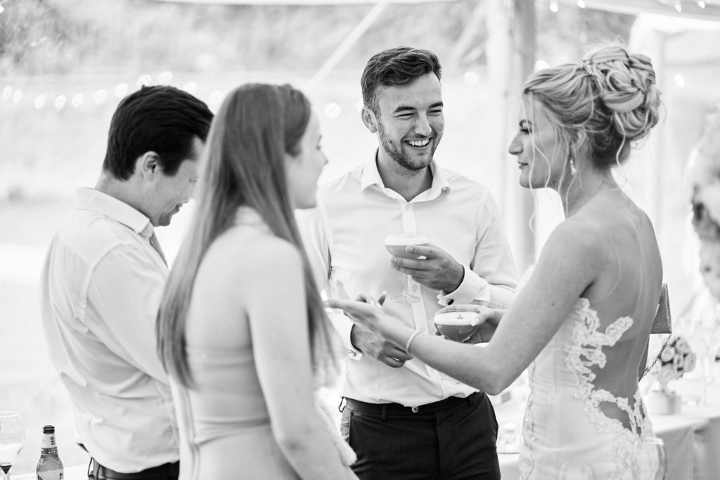 Bride chatting and mingling with guests with cocktail in hand