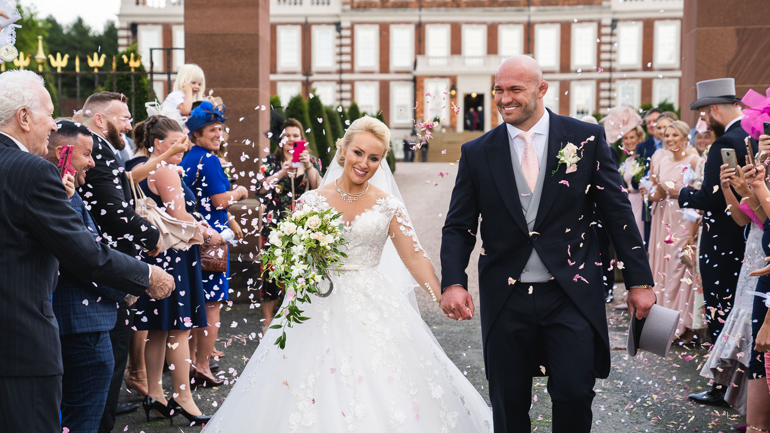 Confetti throwing over the couple at a knowsley hall wedding