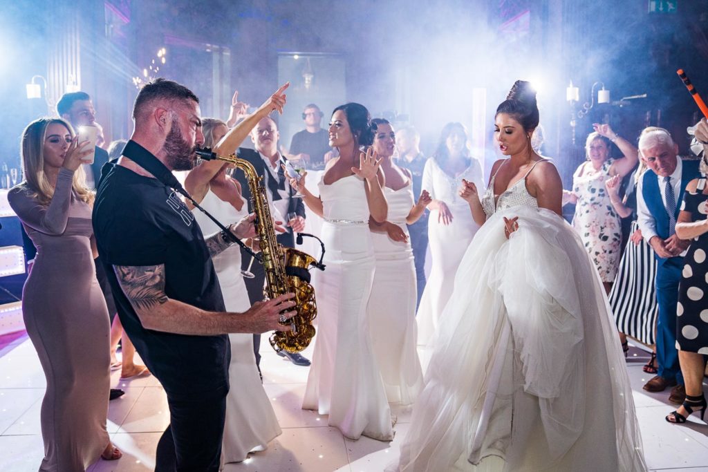 Dax on Sax performing in front of bride as guests dance all around