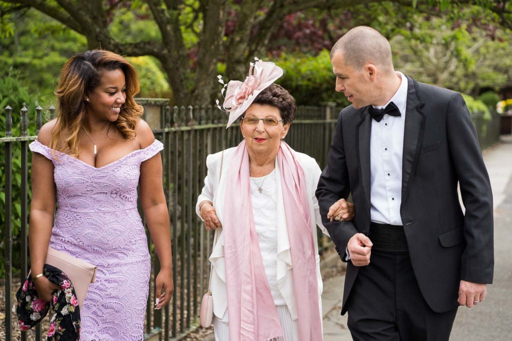 Grandmother of the bride arriving at the church on the arm of her son smiling proudly