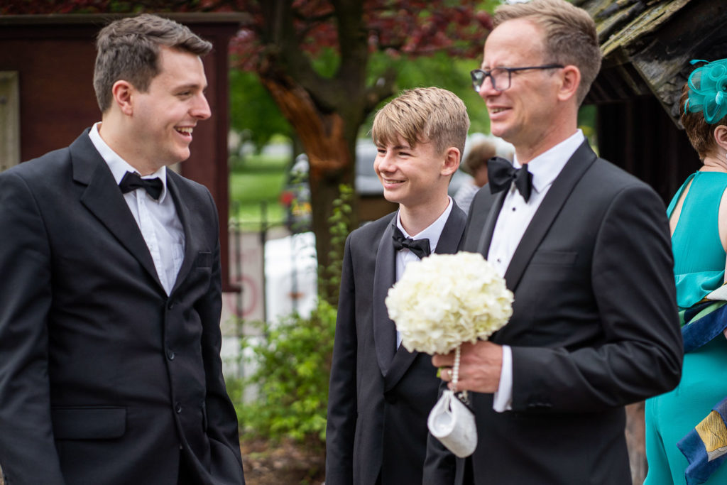 Flower girl's father outside church holding his little girl's posy and clutch bag
