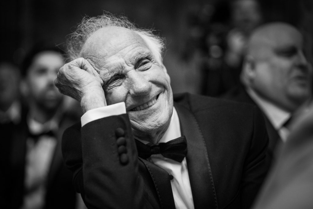 Grandfather of the bride listening to speeches and caught with a huge smile on his face