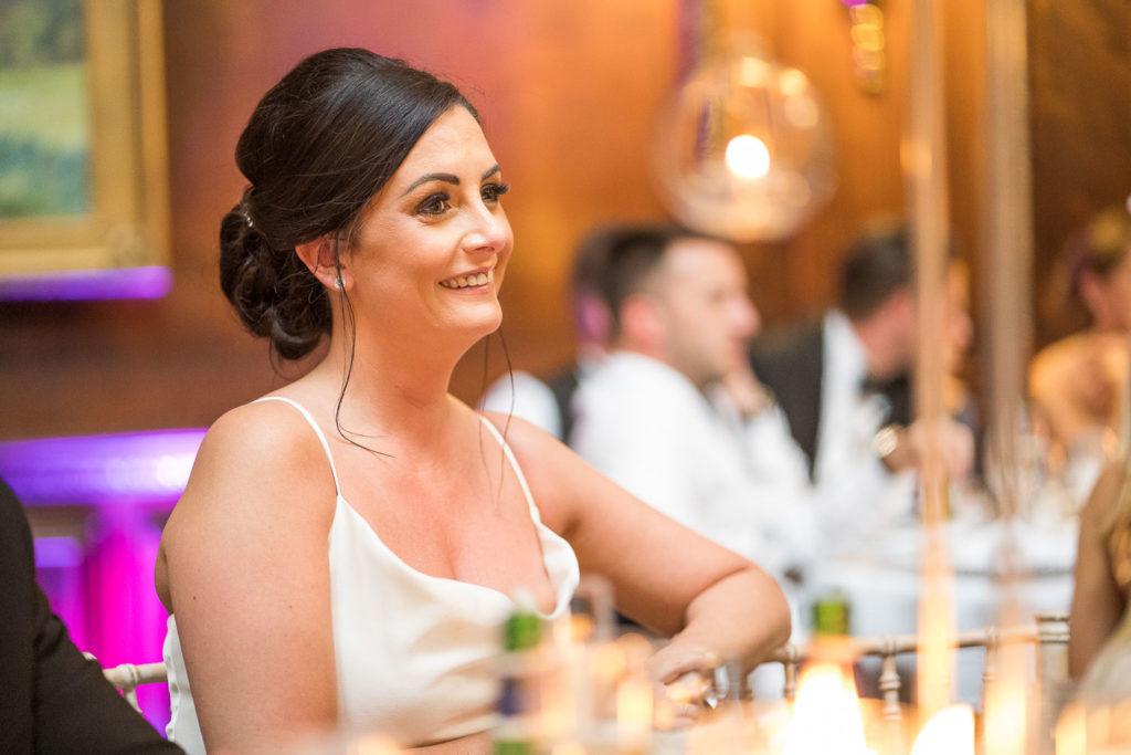 Bridesmaid enjoying Groom's speech wearing a big smile