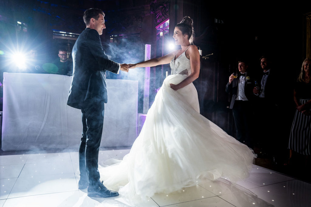 Groom leading his new bride on to the dance floor for their first dance as husband and wife