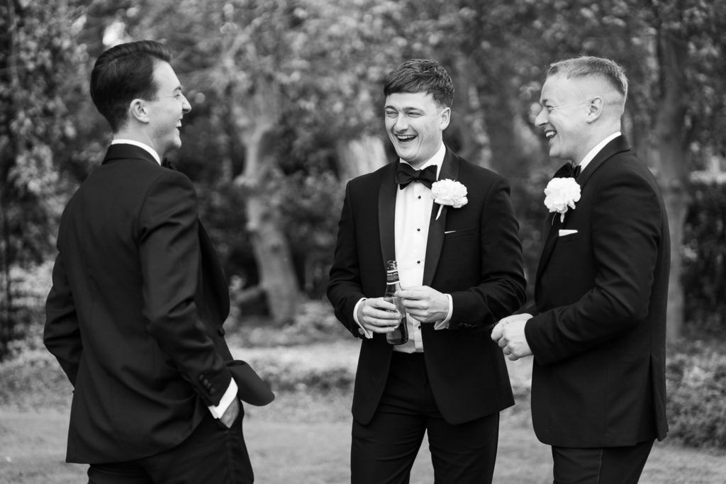 Groom stood laughing and relaxed with two ushers
